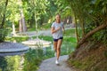 Woman running road summer park