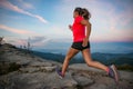 Woman running on rocks. Female cross country running in mountains. Royalty Free Stock Photo