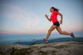 Woman running on rocks. Female cross country running in mountains. Royalty Free Stock Photo