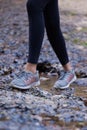 Woman, running shoes and feet in mud while hiking in nature for fitness, exercise and cardio training outdoor for health Royalty Free Stock Photo