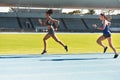 Woman, running and stadium track for race, competition or fitness athletics in the outdoors. Fit, active or sporty women Royalty Free Stock Photo