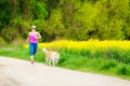 Woman running in summer park with dog Royalty Free Stock Photo