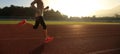 Woman running during sunny morning on stadium track Royalty Free Stock Photo