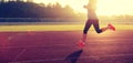 Woman running during sunny morning on stadium track Royalty Free Stock Photo