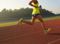 Woman running during sunny morning on stadium track Royalty Free Stock Photo