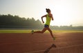 Woman running during sunny morning on stadium track Royalty Free Stock Photo