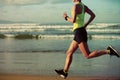 Woman running on sunrise sandy beach