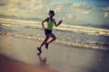 Woman running on sunrise sandy beach