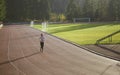 Woman running at sunset on the running track Royalty Free Stock Photo