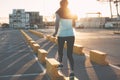 Woman running at sunset. Urban workout in industrial zone. Sporty and fit body