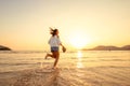 A woman running in to the beach. Woman happy with vacation summer on the beach and sunset Royalty Free Stock Photo