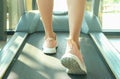 Woman running on treadmill in the gym which runner athletic by running shoes. on white background Health and sport