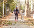 Girl running and walking in beautiful park with akita dog.