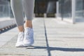 Woman running with white shoes outdoor, sunlight