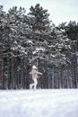 A woman runs through the winter snowy forest alone. girl walking in the woods Royalty Free Stock Photo