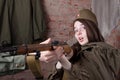 Woman in Russian military uniform shoots a rifle. Female soldier during the second world war. Royalty Free Stock Photo