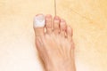 Woman`s bare foot with a bandage on a toe. Wounded toe first aid