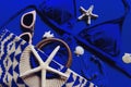 Woman`s beach accessories: bikini, bag, sunglasses, earrings, starfish and shells on electric blue background Royalty Free Stock Photo