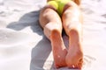 Woman`s beautiful legs on the beach. Tan Woman Applying Sunscreen on Legs. Close-up Royalty Free Stock Photo