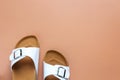 Woman\'s casual trendy white leather sandals on light brown background. Royalty Free Stock Photo