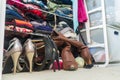 Woman`s closet with high heel shoes, stacked, folded clothes on shelves and part of robes hanging. Depicting closet organization,