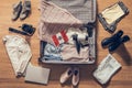 Woman`s clothes, laptop, camer and flag of Mexico lying on the parquet floor near and in the open suitcase. Travel concept.