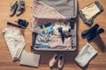 Woman`s clothes, laptop, camer and flag of Sweden lying on the parquet floor near and in the open suitcase. Travel