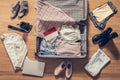 Woman`s clothes, laptop, camer, russian passport and flag of Indonesia lying on the parquet floor near and in the open suitcase.