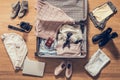 Woman`s clothes, laptop, camera and russian pasport lying on the parquet floor near and in the open suitcase. Travel