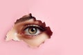 Womans eye peeping through a hole in pink torn paper. Psychology mental health stress concept. Banner template Royalty Free Stock Photo