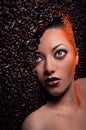 Woman's face over coffee beans Royalty Free Stock Photo