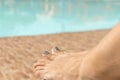 Woman's feet against blue water of the pool. Pair of woman's feet with light blue manicure on blue pool background Royalty Free Stock Photo
