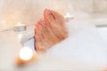 Woman`s feet in bath foam . Relaxation in hotel or spa Royalty Free Stock Photo