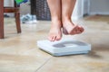 Woman`s Feet Floating Slightly Above Surface of Weight Scale