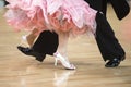 Woman`s feet between man`s feet dancing on parquet floor Royalty Free Stock Photo