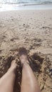 A woman's feet in the sand at the beach on a sea background Royalty Free Stock Photo