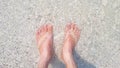 A woman\'s feet. She stands on a beach with beautiful sand and sea Royalty Free Stock Photo