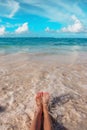 Woman`s feet on the tropical Caribbean beach. Ocean and blue sky Royalty Free Stock Photo