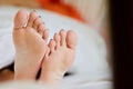 Woman`s feet under the white blanket.rest time, holiday, weekend, woman spending time on the bed, laziness Royalty Free Stock Photo