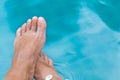 Woman`s female legs in blue swimming pool water Royalty Free Stock Photo