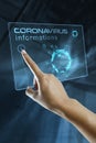 A woman`s finger click information on the corona virus on a digital screen