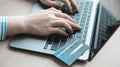 Woman`s finger presses a keyboard and holds a credit card to register for payment or online transactions Royalty Free Stock Photo