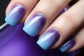 Woman\'s fingernails with blue and purple ombre colored nail polish design