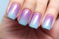 Woman\'s fingernails with pastel blue, pink and purple ombre colored nail polish design