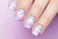 Woman\'s fingernails with pastel colored cloud design nail polish