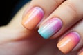 Woman\'s fingernails with pastel colored nail polish