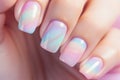 Woman\'s fingernails with pastel colored nail polish