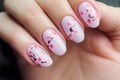 Woman\'s fingernails with pink seasonal spring cherry tree flower nail art design Royalty Free Stock Photo