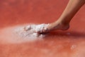 A woman`s foot plunges into the water column of a salty pink lake. Medical procedure. Unique color of lake is given by halophilic Royalty Free Stock Photo