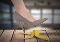 Woman`s foot about to step on banana peel and slip mistakenly on wood Royalty Free Stock Photo